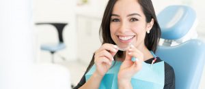 young woman holding Invisalign aligners